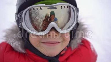 爸爸妈妈反映在男孩滑雪护目镜上。 爸爸妈妈教男孩滑雪或滑雪板。 寒假概念